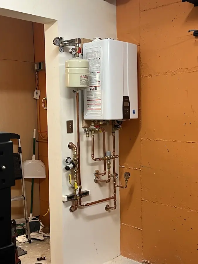Plumbing technician inspecting water heater connections in Sloatsburg